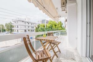 a balcony with two chairs and a table on a balcony at Glyfada's Central Apartment in Athens