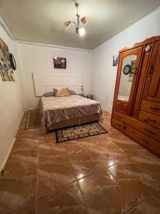 1 dormitorio con 1 cama y armario de madera en Tranquil guest House en Buccoo