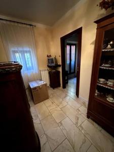 uma sala de estar com piso em azulejo e um quarto com um armário em Casa Felice em Cercola