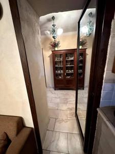 um corredor com um espelho e um armário com garrafas de vinho em Casa Felice em Cercola
