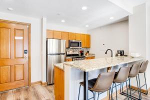 a kitchen with a counter with chairs around it at Chapel Place in Avon