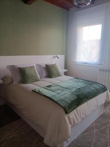 una camera da letto con un grande letto bianco e una finestra di Casa a Antiga Tenda a Santiago de Compostela