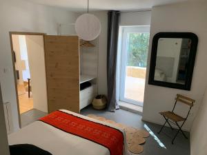 sypialnia z łóżkiem, lustrem i drzwiami w obiekcie Loumaset-agréable petite maison-garrigues de Nîmes w mieście Nîmes +8 zdjęć