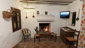 sala de estar con chimenea, mesa y sillas en Casa de Mirasierra, en Bedmar