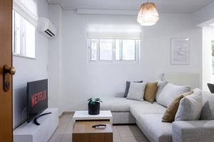 Sala de estar blanca con sofá y mesa en Cozy Stay in Glyfada with WiFi, Garden, Parking, en Atenas