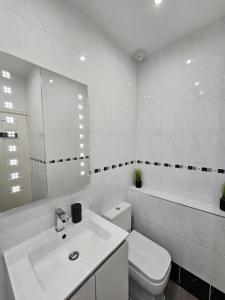 Un baño blanco con inodoro y lavabo. en Lakeview Apartment, central location, Sea and Lake view, free parking & WiFi, en Southport 5 fotos más