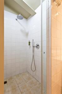 a shower in a bathroom with white tiles at RVA - Porto Central Flats in Porto