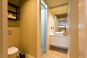 a bathroom with a toilet and a glass shower door at RVA - Porto Central Flats in Porto