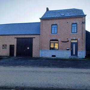 una casa in mattoni con garage e vialetto di Gite Au Cortil a Chevetogne
