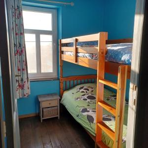 a bedroom with two bunk beds and a window at Gite Au Cortil in Chevetogne