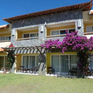 un edificio con flores púrpuras a su lado en Búzios Beach Resort, en Búzios