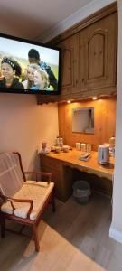 a kitchen with a desk with a tv on the wall at The Yoke in Ballybrittas