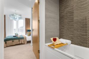 a bathroom with a bath tub and a bedroom at Birmingham City Centre Luxury Apartment in Birmingham