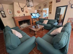 sala de estar con sofás azules y chimenea en La Blanca de Aroche, en Aroche
