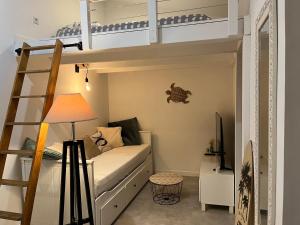 a room with a bunk bed and a lamp at Studio cosy à 15 min de Bordeaux in Saint-Sulpice-et-Cameyrac