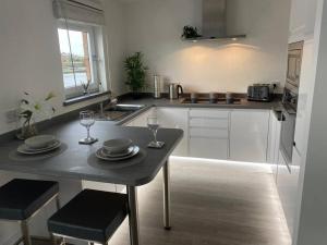 una cucina con tavolo con due piatti e bicchieri da vino di Stunning Refurbished 1 Bedroom, Harbour Apartment. ad Ayr