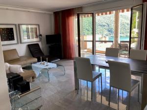 salon ze stołem i kanapą w obiekcie Appartement Novotna w mieście Ponte Tresa
