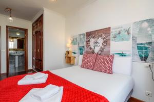 1 dormitorio con cama blanca y manta roja en O Faro Apartments, en Ribadeo