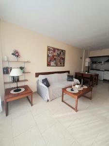 a living room with a couch and two tables at nice apartment in hotel ronda 4 first beach line in Fuengirola