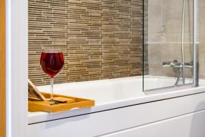 a glass of wine sitting on a tray next to a window at Birmingham City Centre Luxury Apartment in Birmingham