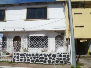 un edificio blanco con ventanas y una valla en Casa Itabaca I en San Cristóbal