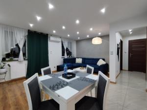 ein Wohnzimmer mit einem Tisch und einem blauen Sofa in der Unterkunft Apartament na Szewskiej in Głogów