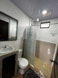 a bathroom with a toilet and a sink and a shower at Casita de Campo in Sardinal