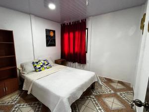 ein Schlafzimmer mit einem Bett und einem roten Vorhang in der Unterkunft Casita de Campo in Sardinal