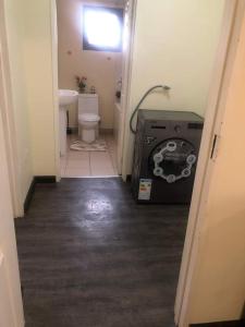 a hallway to a bathroom with a toilet and a sink at LouieVille Apartments in Lusaka