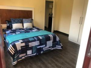 a bedroom with a large bed in a room at LouieVille Apartments in Lusaka