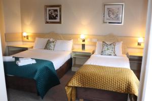 um quarto de hotel com duas camas e uma mesa em Hillview Lodge em Armagh