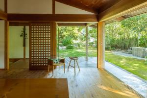 Habitación con mesa, sillas y suelo de madera. en 木木木木 KIGI MOKU MOKU, en Sasebo
