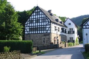 a large black and white building on a street at Haus Wiesengrund in Hürtgenwald