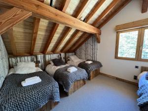 een slaapkamer met 3 bedden in een kamer bij Châlets AOKI in Valloire