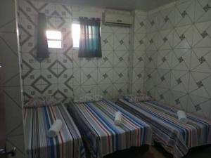 Cama pequeña en habitación con pared en Pousada Trilha do Pelo en Salvador