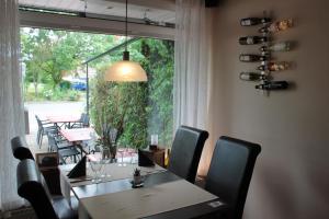 a dining room with a table and chairs and a large window at Restaurant Fischbeck´s in Großenkneten