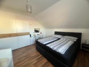 a bedroom with a black bed in a room at Bogi's Ferienhaus - Pension in Laakirchen