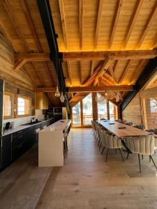 een keuken met een lange tafel en stoelen in een kamer bij Châlets AOKI in Valloire