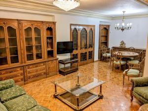salon z drewnianymi szafkami i szklanym stołem w obiekcie Comunidad Valenciana 31 w mieście Elche