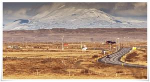 a road with a snow covered mountain in the background at Guesthouse Bitra B&B in Selfoss