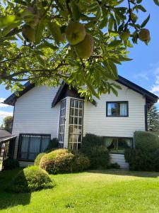 una casa con un naranjo delante de ella en Casa Las Violetas en San Carlos de Bariloche