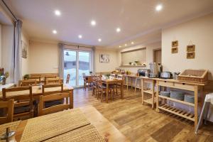 un restaurant avec des tables et des chaises en bois et une cuisine dans l'établissement Residence Ruth, à Janské Lázně