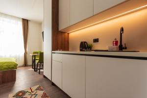 a kitchen with white cabinets and a bed in a room at Apartments EMERALD Free Garage Parking in Sarajevo
