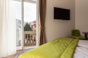 a bedroom with a bed and a window with a view at Apartments EMERALD Free Garage Parking in Sarajevo