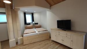 1 dormitorio con 2 camas y un tocador con TV en Haus Toskana, Kleines Ferienhaus im Toskanagarten, en Bad Sulza