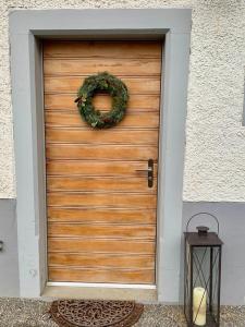 a wooden door with a wreath on it at Bed & Breakfast Gaetzi in Windlach