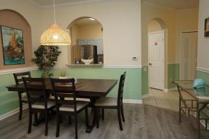 a kitchen and dining room with a wooden table and chairs at Windsor Hills Resort- 101A in Orlando