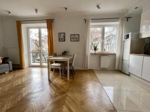 a living room with a table and a kitchen at Charming apartment in Old Mokotów in Warsaw
