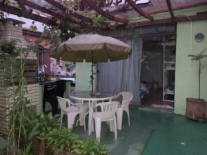 a patio with a table and chairs and an umbrella at Hostel Jardim da Saúde in São Paulo