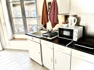 a kitchen with a microwave and a sink at Studio atypique centre Vivonne in Vivonne